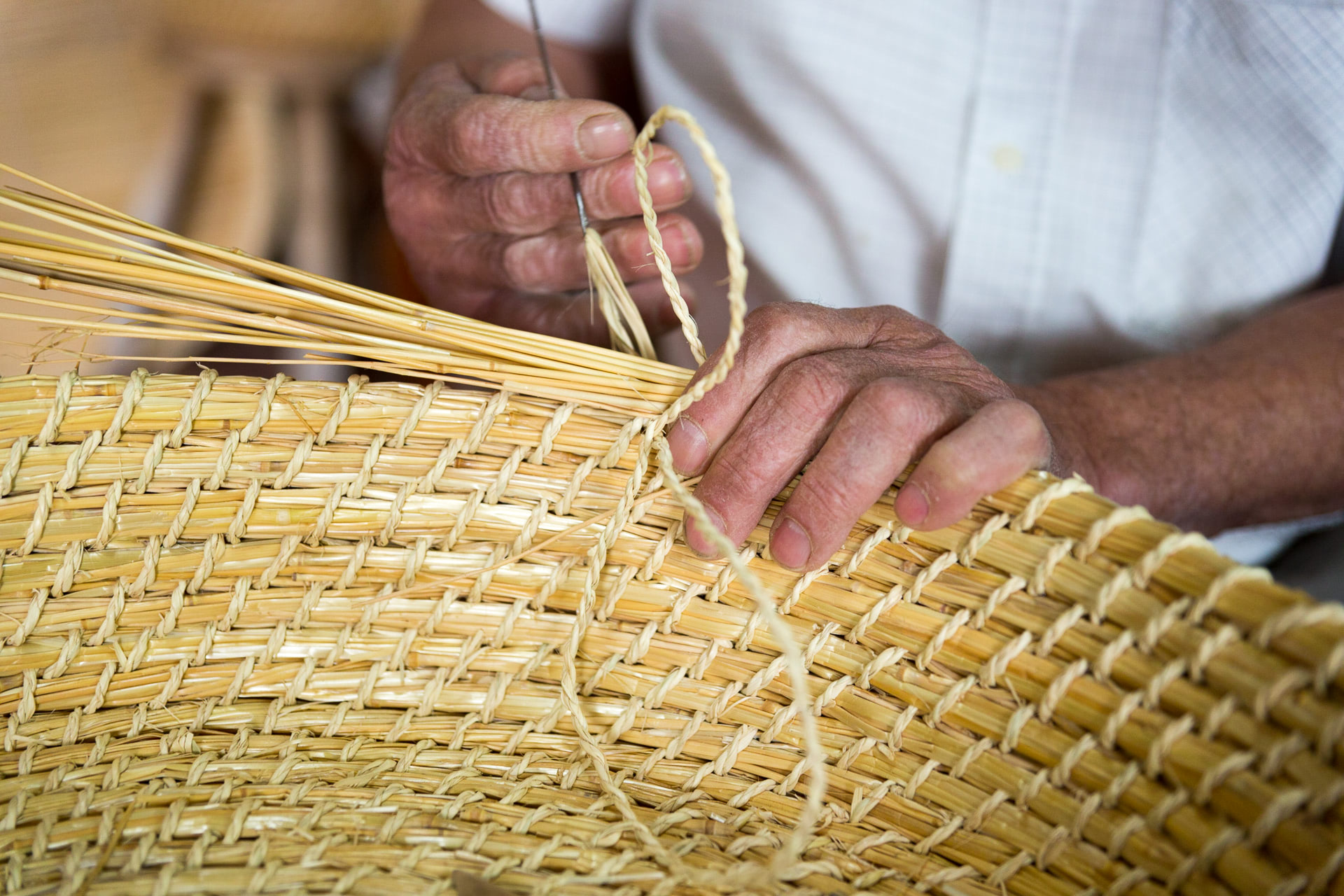 Agricultor elaborando un cesto de caña.